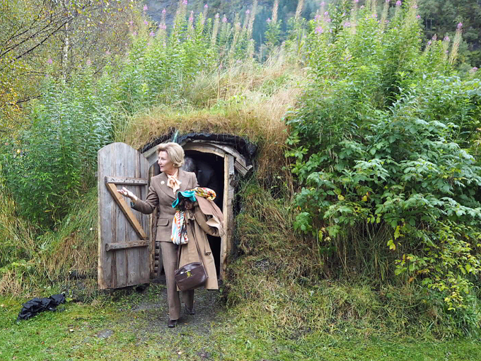 The Queen exits a turf hut after speaking with children around the bonfire. Photo: Liv Anette Luane, The Royal Court