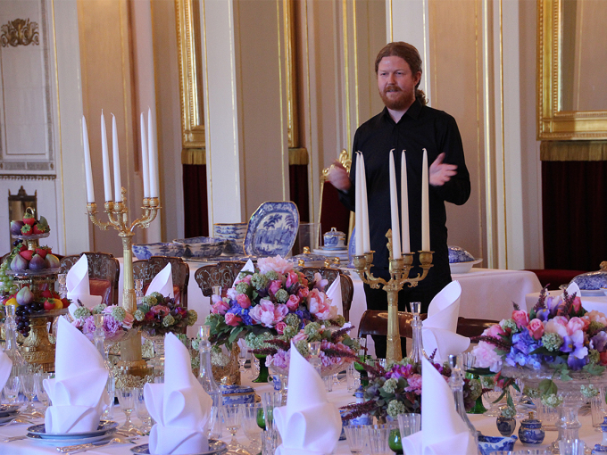 Kjartan Hauglid fra De kongelige samlinger forteller om bordet og alt som skulle til for å dekke et slikt bord i en tid uten moderne hjelpemidler. Foto: Liv Osmundsen, Det kongelige hoff.