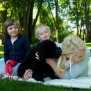 The Crown Prince and Crown Princess' family in the garden at Bygdø, enjoying their puppy Milly Kakao (Photo: Veronica Melå, Det kongelige hoff)